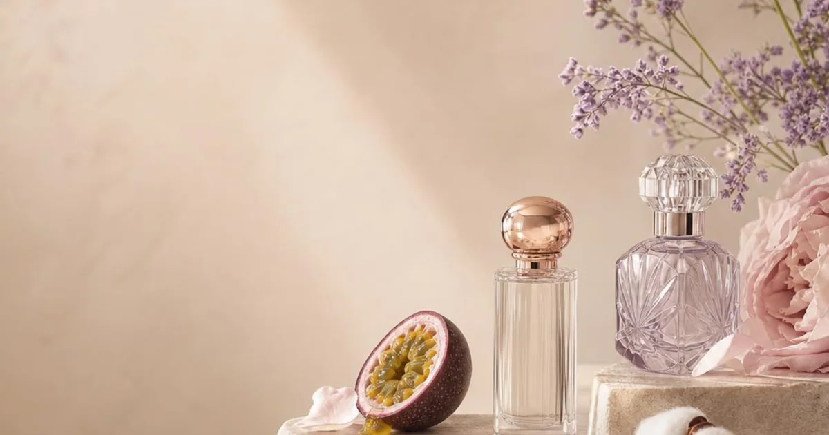 Tropical fruit, vanilla, pink petals, cotton, and translucent glass in an airy pastel fragrance still life.